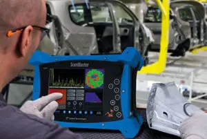 Técnico realizando ensayo no destructivo con equipo industrial